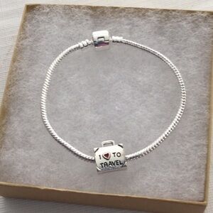 Woman’s Bracelet with one charm that reads I love to travel color sliver.NWOT
